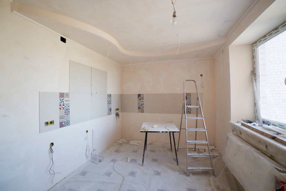 Spacious kitchen under renovation with ladder and tools, showcasing a fresh new design
