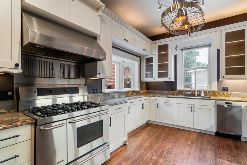 Spacious kitchen with stainless steel appliances, granite countertops, and wooden flooring